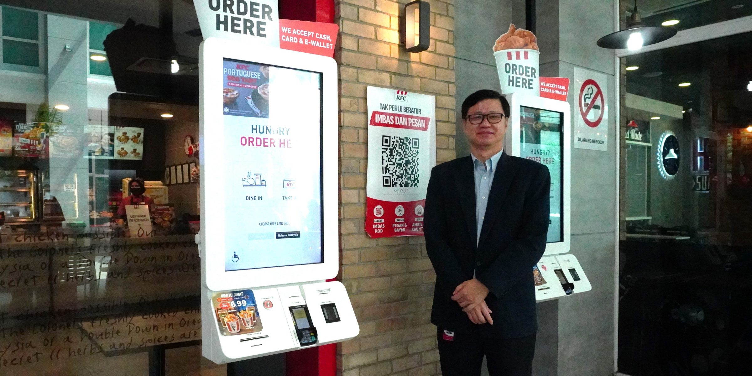 Photo of QSR Brands' Group Chief Information Officer with KFC's self serving kiosks.