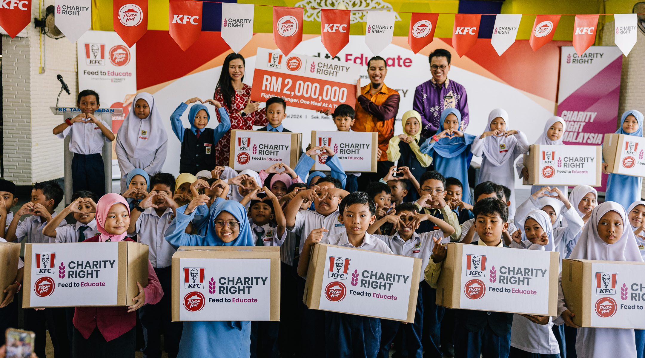 Group photo with students of SK Taman Medan during the launch of KFC and Pizza Hut's Feed to Educate program.
